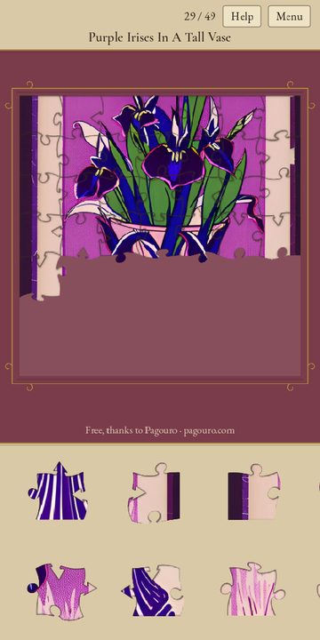 A puzzle of purple irises half done, with loose pieces in the tray along the bottom